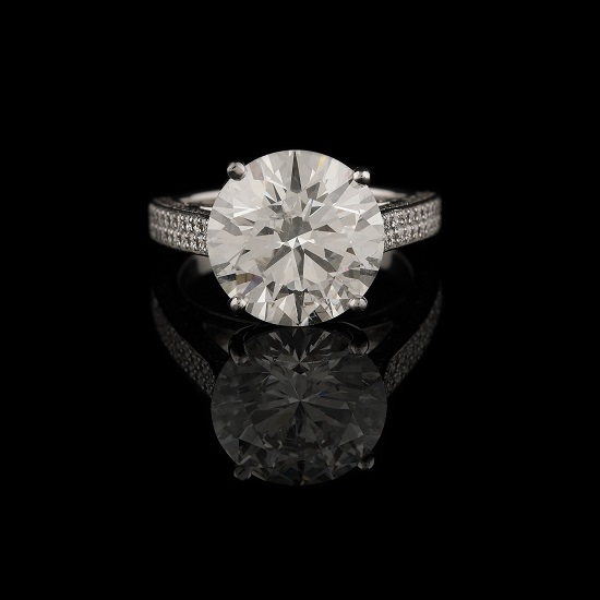 Impozant inel din aur alb, decorat central cu un diamant cca. 6 ct., în anturaj de briliante